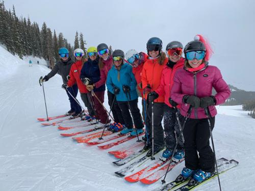 Nine woman line up at Crested Butte, all skiing on Elan Ripstick skis.

