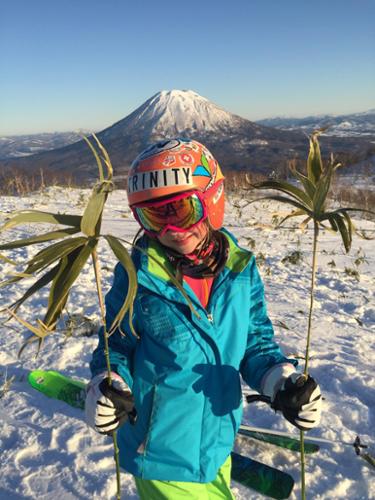 Krista Crabtree's daughter holds up bamboo leaves with Japan's Mt. Yotei in the background.