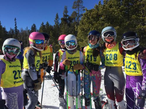 Middle school ski racers pose in their race bibs before their race.