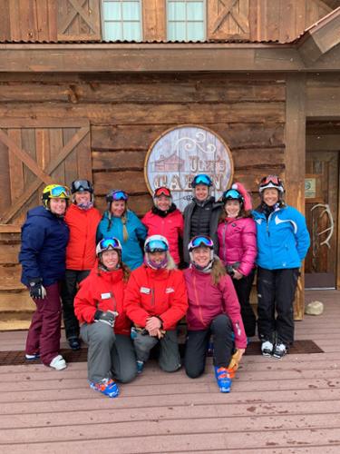 A group of female skiers pose in front of a restaurant at Crested Butte.