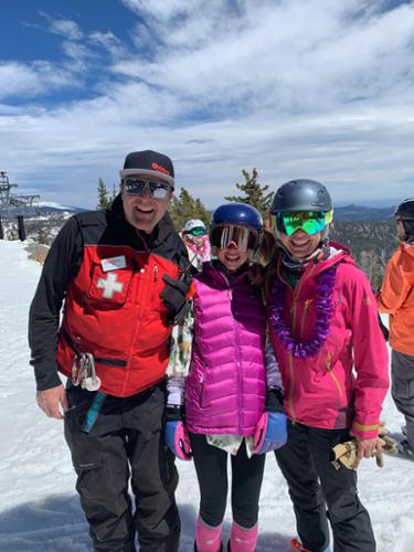 A ski patroller, a junior racer and mom pose at the top of Eldora Mountain Resort.