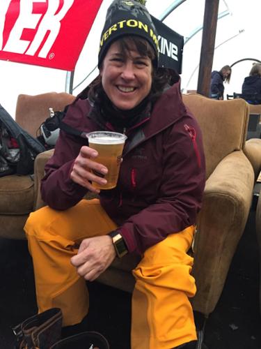 A woman drinks a beer in the yurt after skiing at Silverton Mountain.